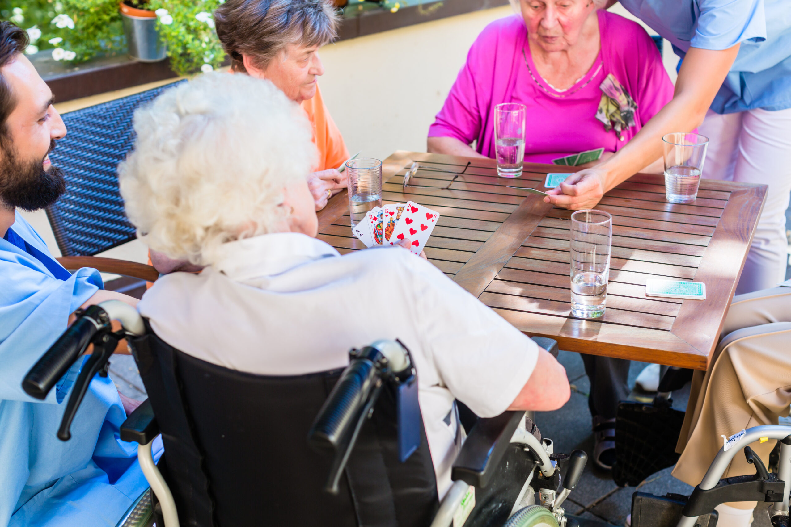 An image of residents playing cards at an assisted living facility.