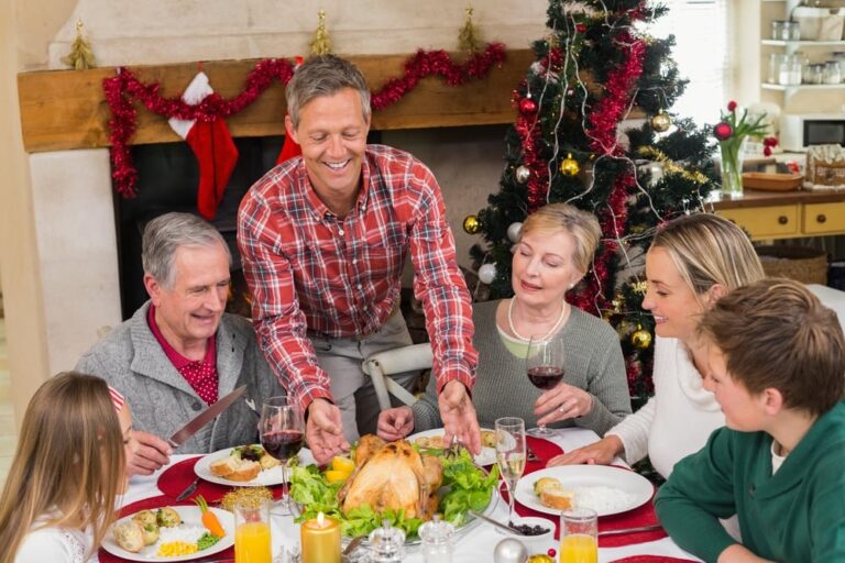 Man serving roast turkey at Christmas at home in the living room